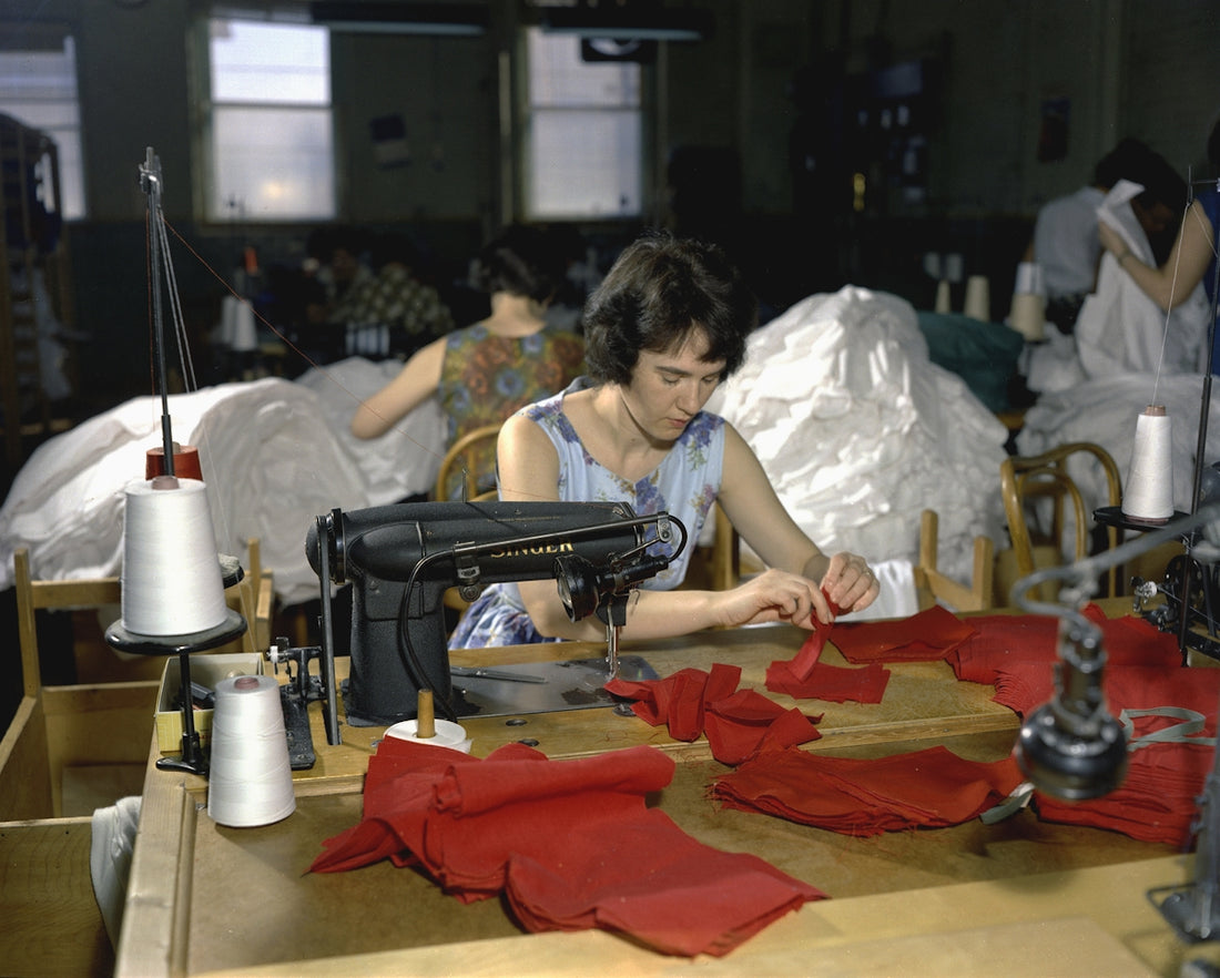 a woman sitting at a table with a sewing machine