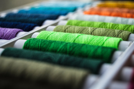 a row of spools of thread sitting on top of a table