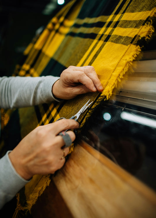 a person cutting a piece of fabric with a pair of scissors