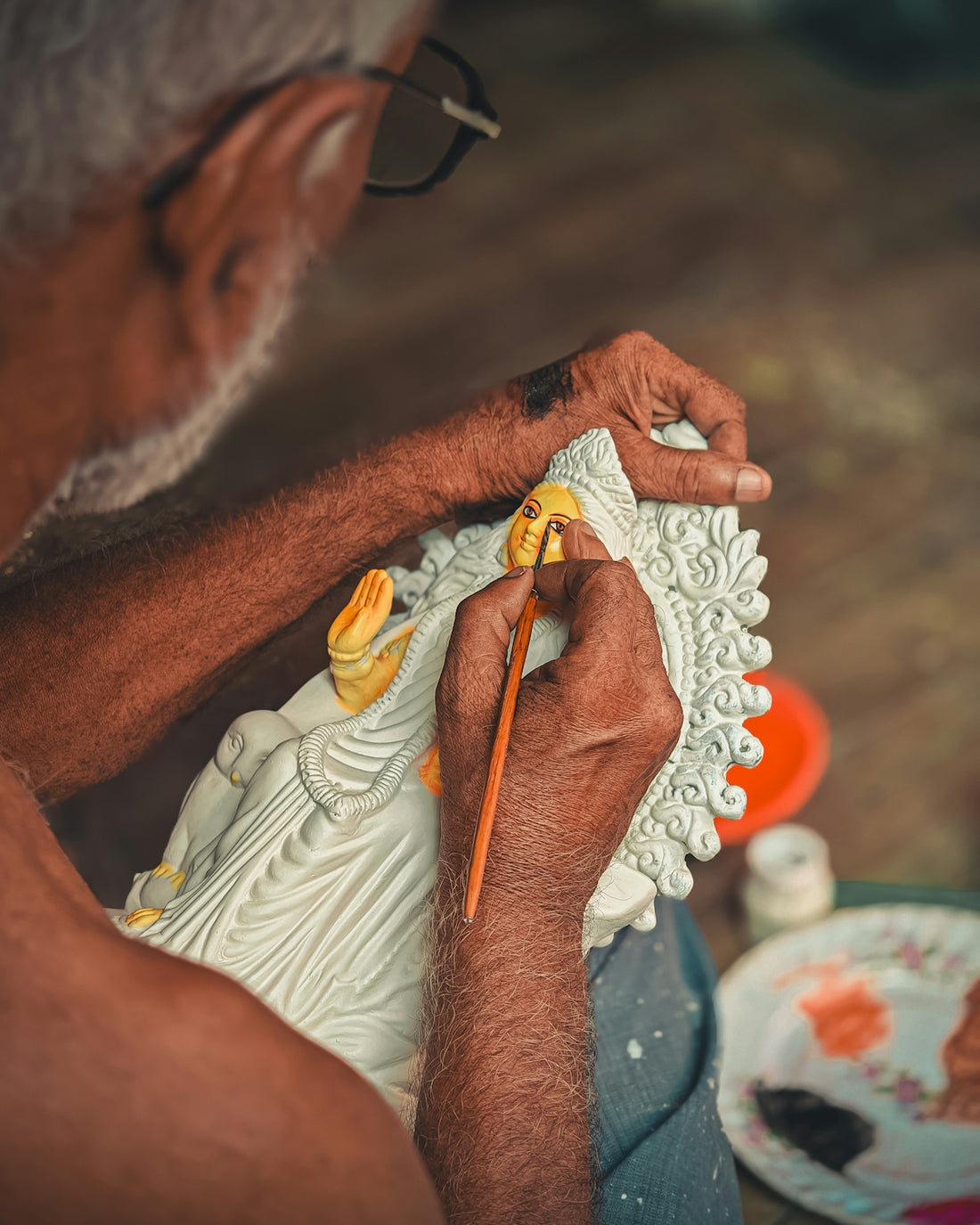 A man is painting a picture on a plate
