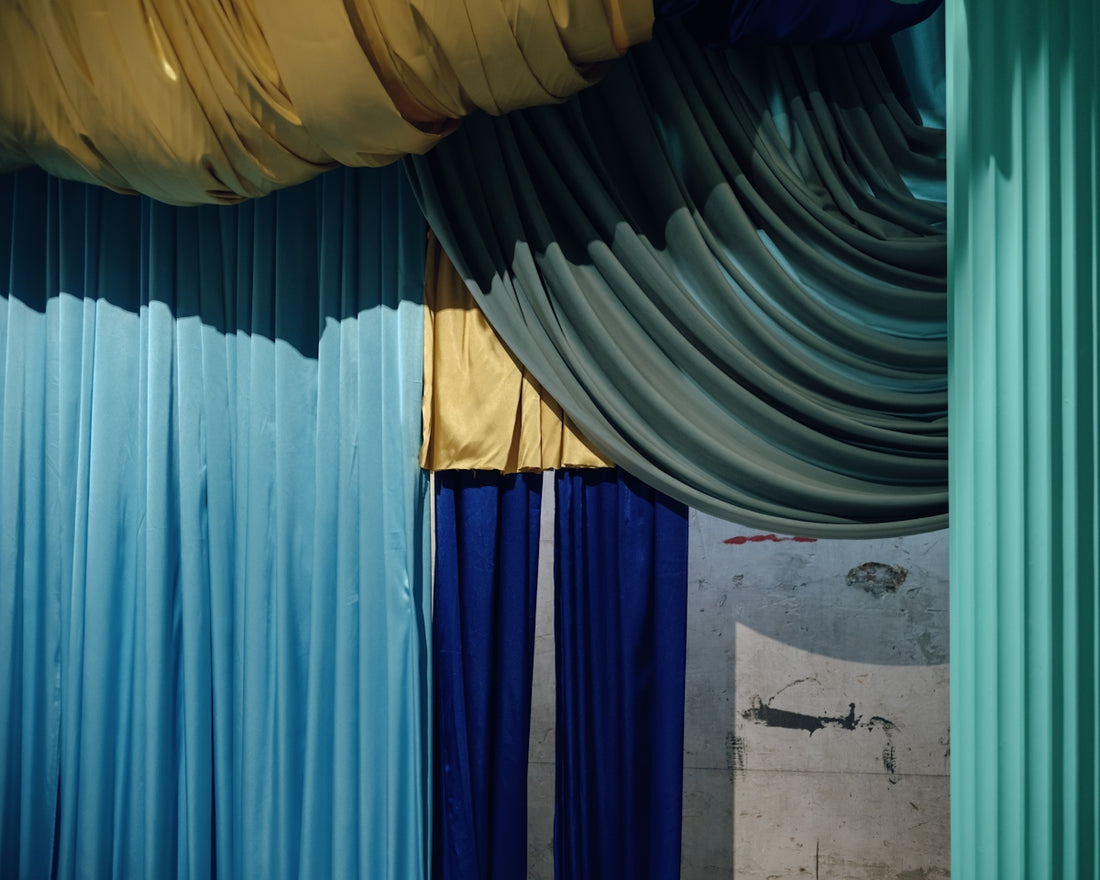 Colorful fabrics drape in a theatrical arrangement.