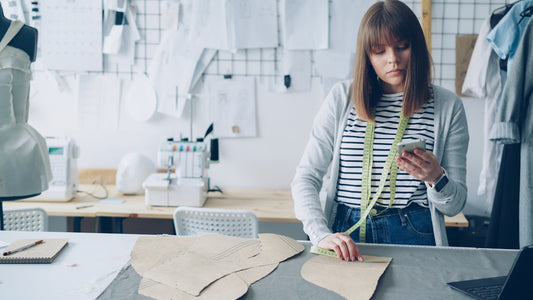 Fashion designer works on patterns in her studio.
