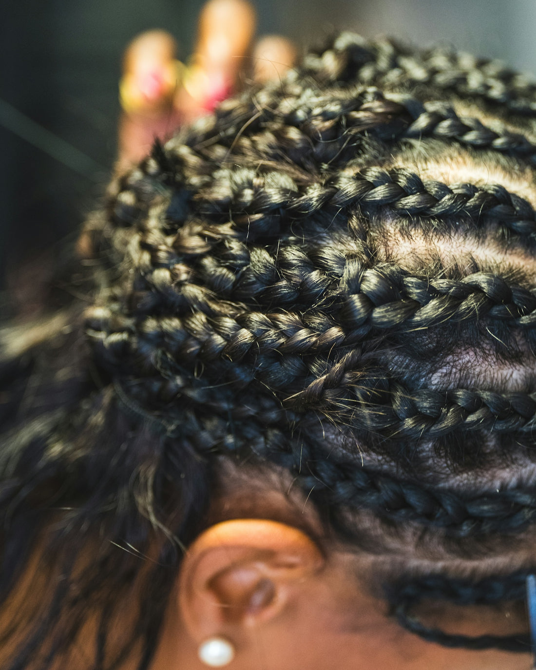 Close-up of a person getting their hair braided