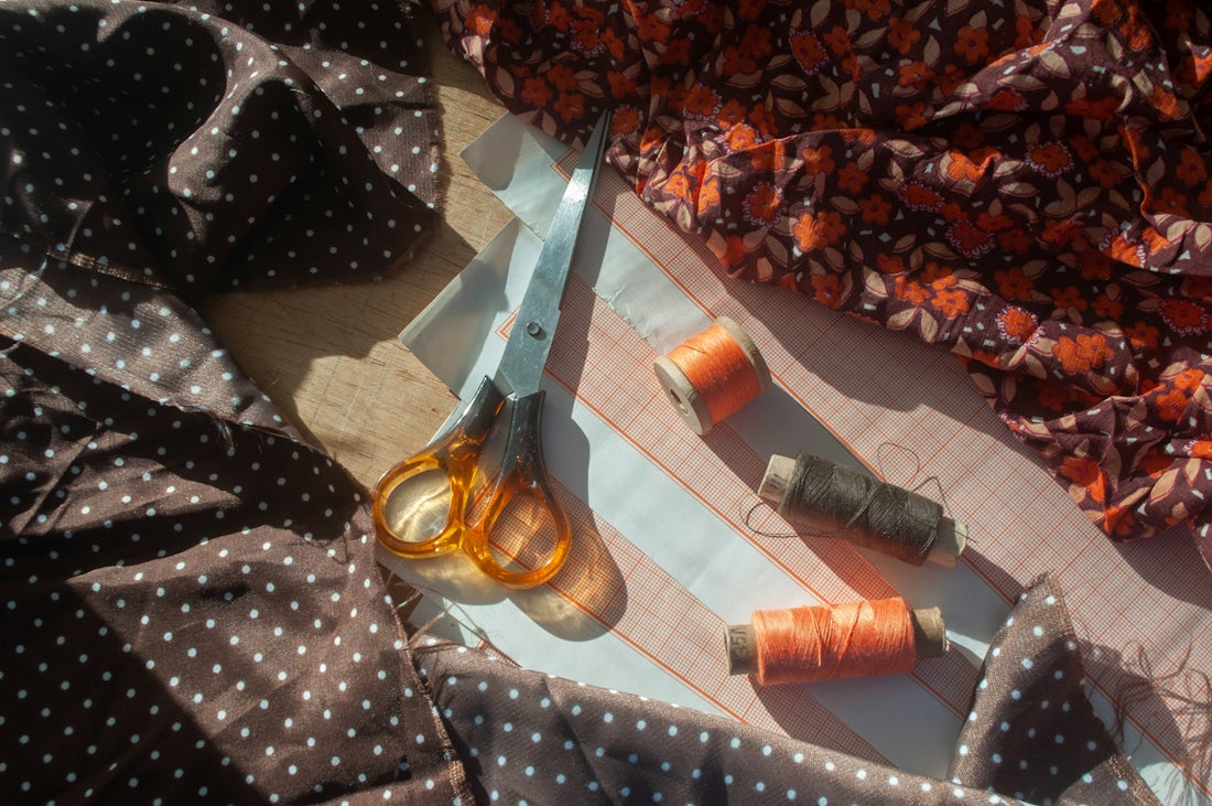 Scissors and spools of thread on fabric
